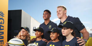 Waratahs player Clem Halaholo (left) and Wallaby player Reece Hodge (right) pose with young players at the launch of Australia’s Rugby World Cup 2027 bid.