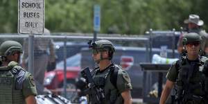 Law enforcement personnel stand outside Robb Elementary School following the shooting.