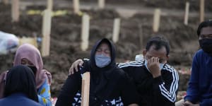 Family members weep during the burial of a relative at Jakarta’s Rorotan Cemetery which is reserved for those who die of COVID-19.