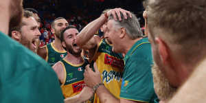 Tasmania JackJumpers players celebrate their semi-final win over Perth with coach Scott Roth.