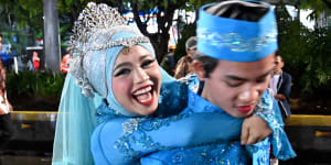 A couple poses for photos as they join over 500 other couples at a mass wedding event in Jakarta.
