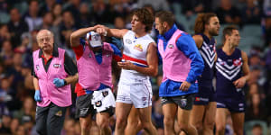 Liam Picken is assisted from the field during a 2017 game against Fremantle.