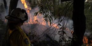 A bushfire burning behind homes near Woodford in the Blue Mountains on Friday. 