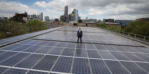 Cr Nick Reece on a roof with solar powered panels.