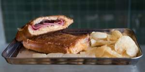 Toasted reuben with pastrami,sauerkraut,gruyere cheese and Russian dressing – and potato crisps on the side.