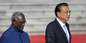 Solomon Islands Prime Minister Manasseh Sogavare,left,walks with Chinese Premier Li Keqiang in October 2019. 