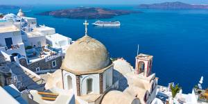 Fira town in Santorini island in Greece with cruise ship in the background.