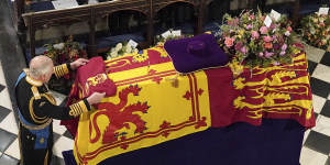 King Charles III places the Queen’s Company Camp Colour of the Grenadier Guards on the coffin.