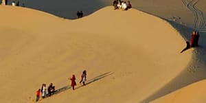 Residents walk on sand dunes in the Libyan desert oasis town of Ghadames