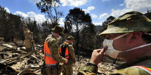 Members of the army's Victorian search task group inspect properties and look for bodies in Flowerdale,three days after Black Saturday.