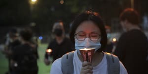 A women holds candle during a vigil to remember the victims of the 1989 Tiananmen Square Massacre.