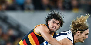 Tom Stewart of the Cats tackled by Ned McHenry of the Crows.