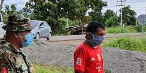 A road checkpoint in Baucau,Timor-Leste,where vehicles are sprayed inside and out,and a tank provides hand-washing water. 