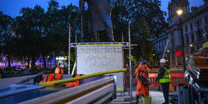 Workers erect the protective barrier under the cover of darkness. 