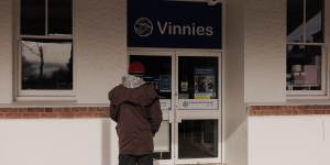 A man reads a sign notifying customers that Vinnie’s in Cooma is closed for the day in memory of Nowland.