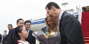 Syrian President Bashar al-Assad,right,and first lady Asma al-Assad receive a bouquet of flowers from a young girl as they arrive in Hangzhou,China,on September 21.