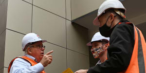 NSW Building Commissioner David Chandler,left,talks about the removal of cladding from a Darlington apartment building.