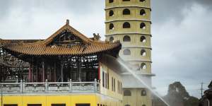 Firefighters put out spot fires at the Buddhist temple in Springvale on Monday morning. 