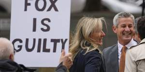 A protester holds a sign near representatives of Fox News outside the justice centre for the Dominion Voting Systems’ defamation lawsuit against Fox News in Wilmington.