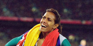 Cathy Freeman takes the Australian and Aboriginal flags on a victory lap after winning gold.