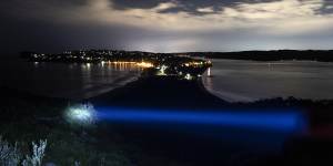 A blue torchlight beam shines over the view of Palm Beach looking south from the lighthouse.