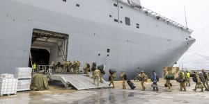 Soldiers entering the HMAS Adelaide at the Port of Brisbane on Thursday last week,before departing for Tonga. 