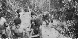 Papuan bearers (nicknamed the fuzzy-wuzzy angels) carry an Australian casualty through thick jungle at Eora Creek,1942.