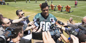 Centre of attention:Jordan Mailata is tackled by a media scrum after making the Eagles'final roster.