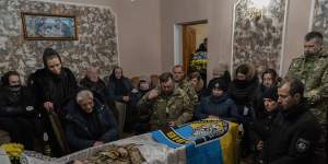 Relatives and friends mourn the body of senior police sergeant Roman Rushchyshyn in the village of Soposhyn,in the outskirts of Lviv,western Ukraine.