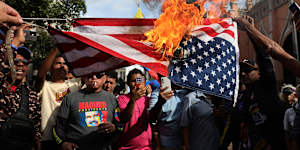 Supporters of ousted Venezuelan President Nicolás Maduro burn a US flag in Caracas.