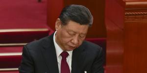 Chinese President Xi Jinping looks through documents during the opening session of the National People’s Congress.