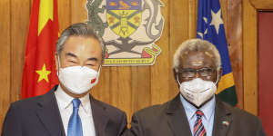 Solomon Islands Prime Minister Manasseh Sogavare,right,locks arms with visiting Chinese Foreign Minister Wang Yi in Honiara,Solomon Islands on May 26,2022.