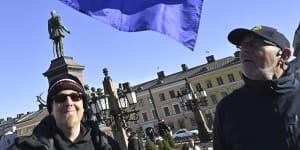 Two Finnish people with a NATO flag celebrate at the Senate Square in Helsinki,Finland.