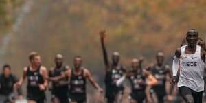 Eliud Kipchoge approaches the finish line after running 1:159 in a marathon in 2019,with his pacemakers celebrating behind. 