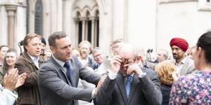 A scene from true crime drama Mr Bates vs The Post Office,showing victimised subpostmasters reacting to a High Court judgment in their favour. 