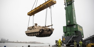 An M1A2 Abram tank is raised over the pier at the Port of Vlissingen,Netherlands,to be lowered onto a low-barge ship for transportation to another location within Europe in 2019.