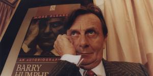 Barry Humphries with the cover of his autobiography behind him.