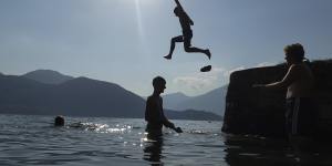 Boys dive into Lake Como,at Lierno,northern Italy.