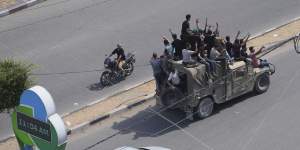 Hamas militants drive a captured Israeli military vehicle in Gaza City at the weekend.
