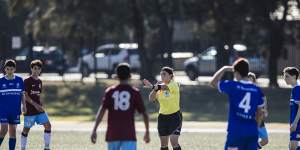 A young referee oversees a soccer match between Hakoah Sydney City East and APIA Leichhardt Tigers at Hensley Athletic Field in Eastlakes.