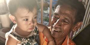 Sudech Paneha with his grandson Tulyawat Prasomkaen,aged one. The extended family lives on the bank of the Tapi River.