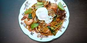 Hokkien noodles stir-fried with prawns,mussels and sliced pork,and topped with dried fish and runny fried egg.