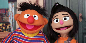 Ji-Young (right),pictured with longtime Sesame Street character Ernie,is the first Asian-American Muppet on the long-running children’s program. 