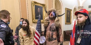 FILE - In this Wednesday,Jan. 6,2021 file photo,supporters of President Donald Trump,including Jacob Chansley,center with fur and horned hat,are confronted by Capitol Police officers outside the Senate Chamber inside the Capitol in Washington. A video showed Chansley leading others in a prayer inside the Senate chamber. (AP Photo/Manuel Balce Ceneta)