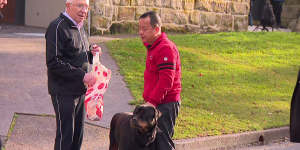 “Owen” Ouyang Chen (right) and his dog on Cliff Road in Northwood after one of his properties was set alight.
