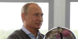 Russian President Vladimir Putin holds a globe presented him as a gift during his meeting with participants in the youth educational forum near Lake Seliger in Russia.