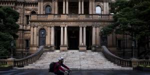 A delivery rider passes Sydney’s Town Hall.