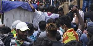 Protesters,many carrying Sri Lankan flags,gather outside the presidents office in Colombo on Saturday.