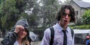 Student trudge through floodwater on Macpherson Street,Warriewood.
