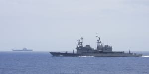 A Taiwanese navy ship Keelung,foreground monitors the Chinese aircraft carrier Shandong in the background near Taiwanese waters.